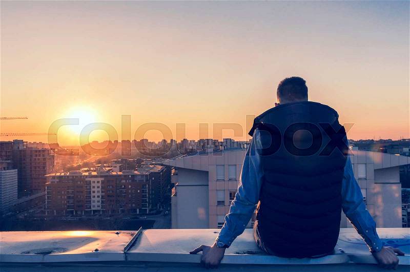 Man on the roof top watching sunset,selective focus , stock photo