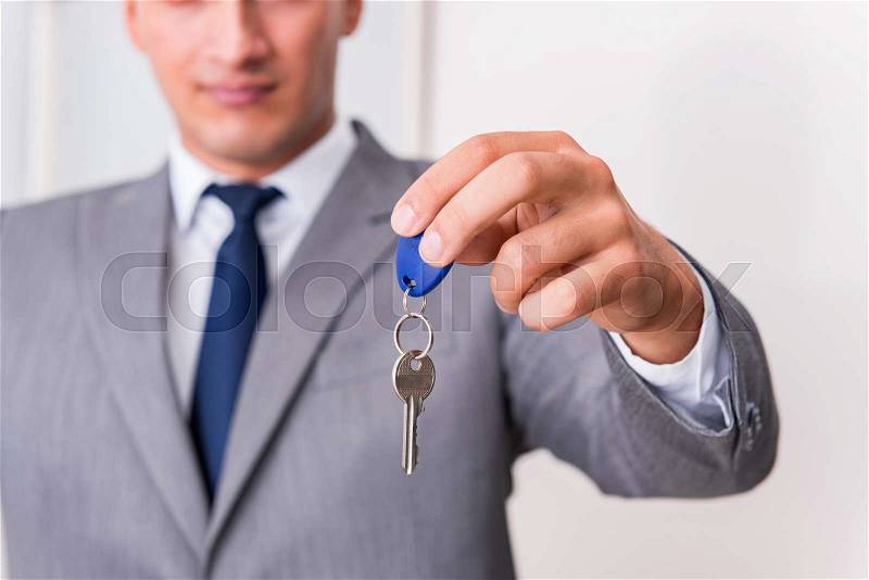 Real estate agent with key from new house, stock photo