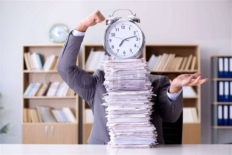 Businessman struggling to meet challenging deadlines, stock photo