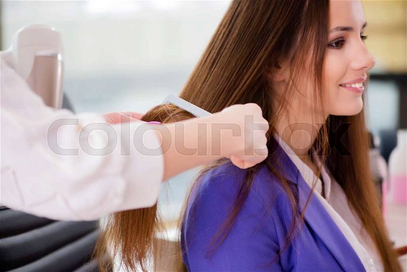 Woman getting her hair done in beauty shop, stock photo