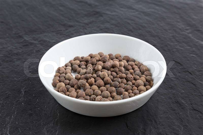 Allspice in a bowl on a slate, stock photo