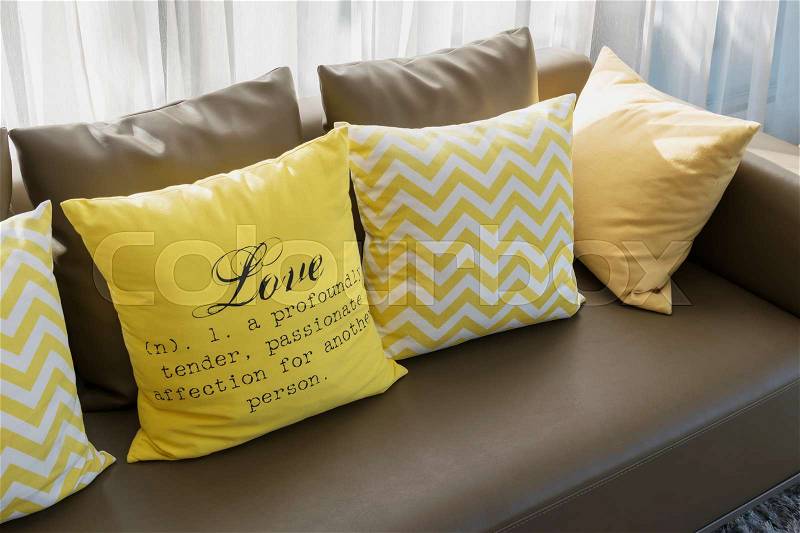 Modern living room design with brown sofa and yellow pillows, stock photo