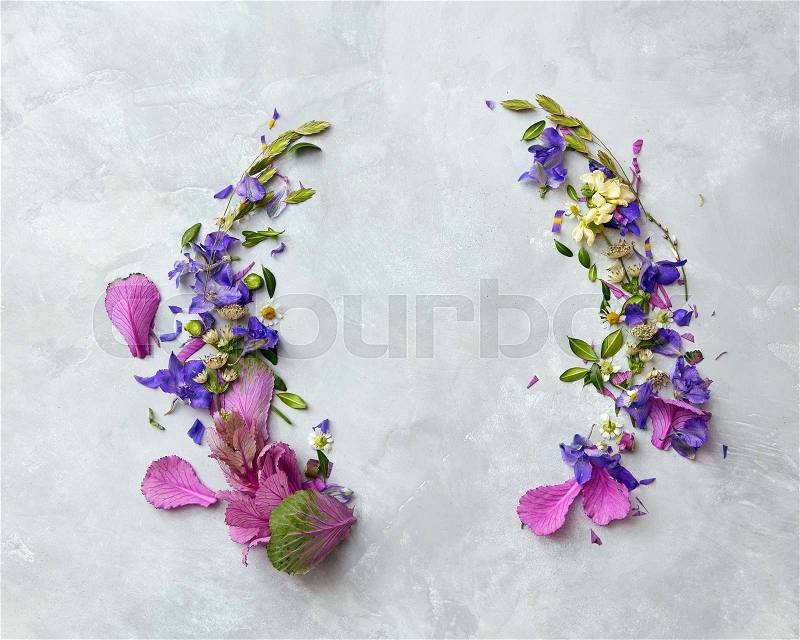 Round frame of purple flowers with space for text on a concrete background, stock photo
