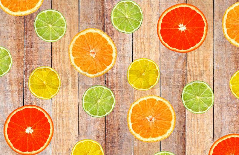 Slices of citrus fruits lime, lemon, orange, grapefruit on wood table, top view, stock photo