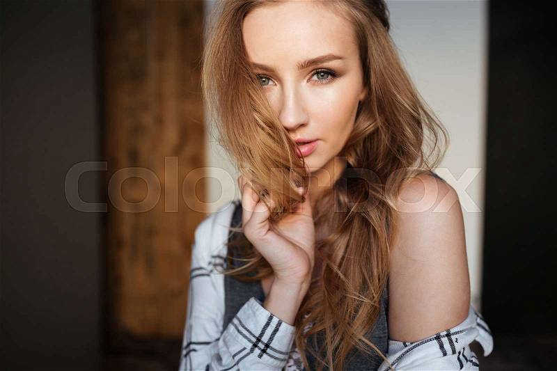 Portrait of young amazing woman posing indoors dressed in lingerie and shirt. Look at camera, stock photo
