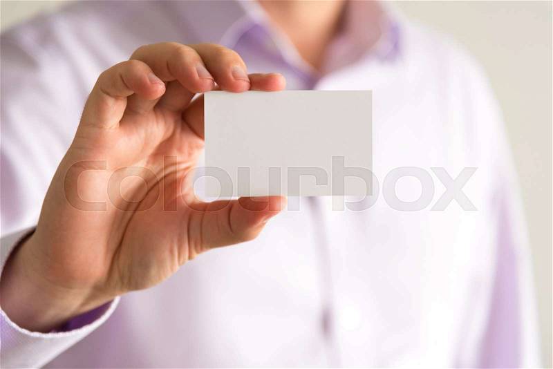 Closeup on businessman holding white empty message card with copy space for text, business concept image with soft focus background, stock photo
