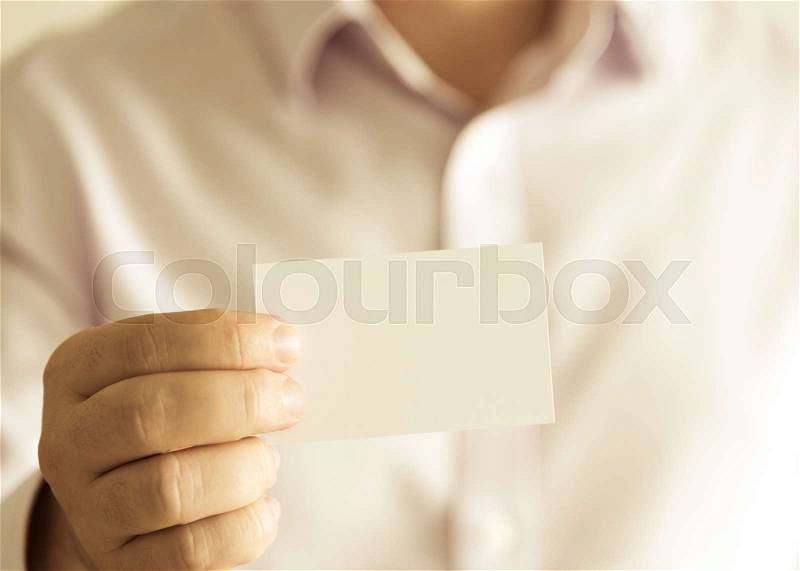 Closeup on businessman holding white empty message card with copy space for text, business concept image with soft focus background and vintage tone, stock photo