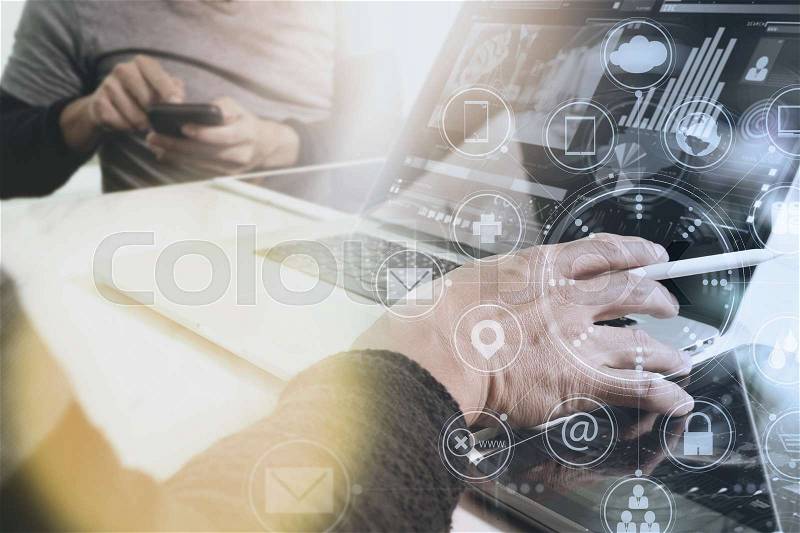 Designer Businessman hand using smart phone,mobile payments online shopping,omni channel,digital tablet docking keyboard computer in modern office on wooden desk,virtual interface icons screen, stock photo