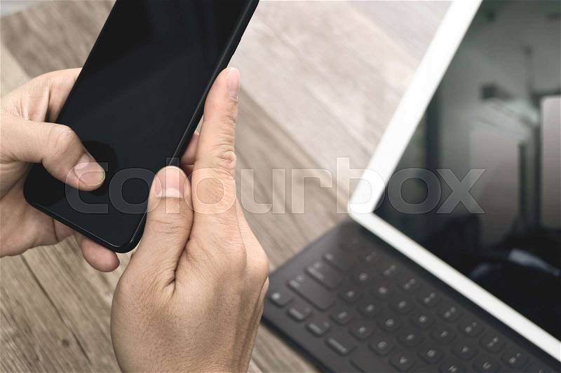 Hand using mobile payments online shopping,omni channel,icon customer network,in modern office wooden desk, blank interface screen,filter effect, stock photo