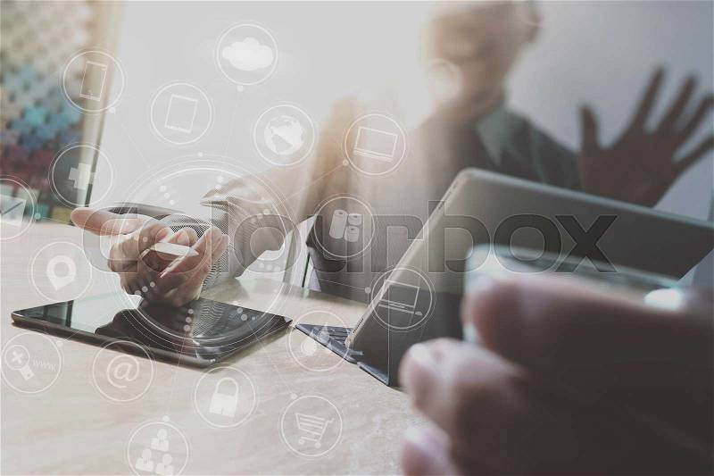 Designer Businessman hand using smart phone,mobile payments online shopping,omni channel,digital tablet docking keyboard computer in modern office on wooden desk,virtual interface icons screen, stock photo