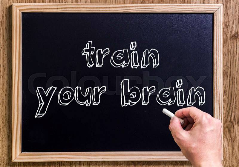 Train your brain - New chalkboard with 3D outlined text - on wood - with hand, stock photo