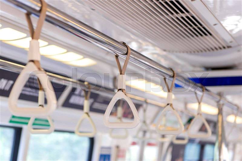 Handles on ceiling for standing passenger inside a bus, stock photo