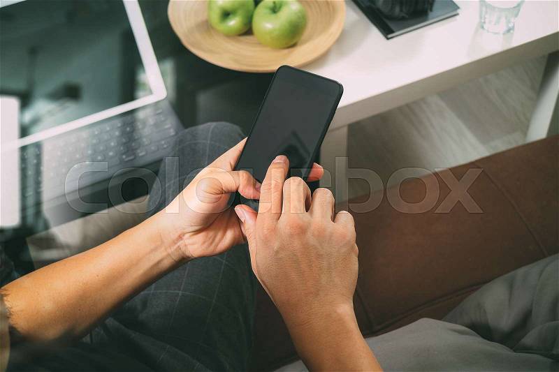Hipster hand using smart phone for mobile payments online business,headphone,sitting on sofa in living room,green apples in wooden tray,graphic interfce icons virtual screen,filter, stock photo