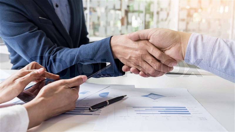 Business handshake of two men demonstrating their agreement to sign agreement or contract between their firms, companies, enterprises, stock photo