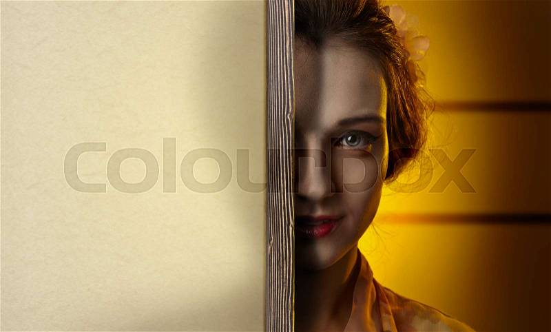 Happy young beautiful woman behind the paper screen, free space for your text, stock photo