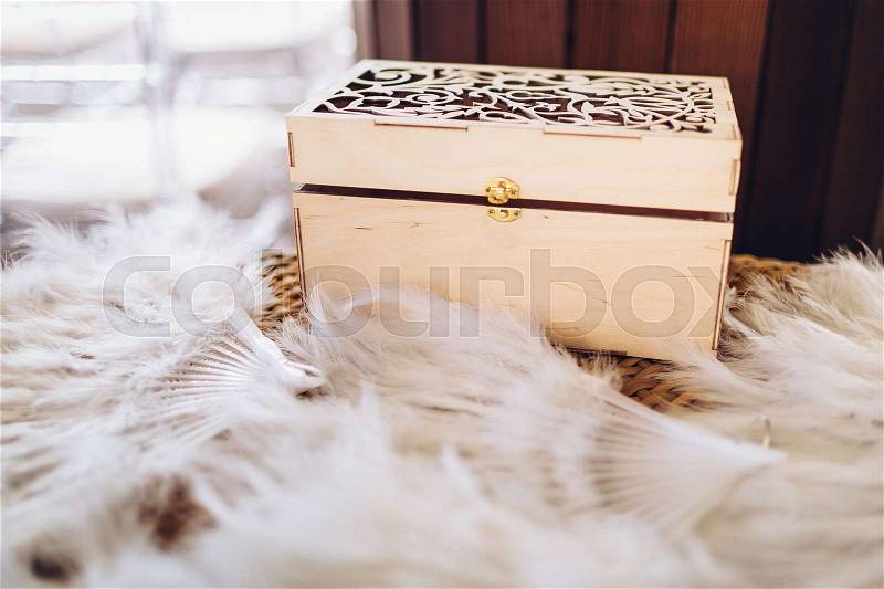 Nice wooden decorative box with feather fans. Close-up, stock photo