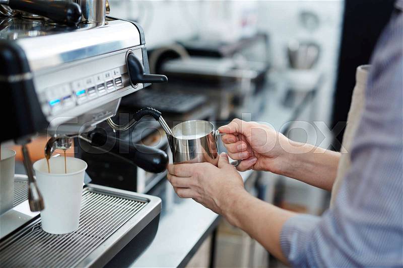 Barista frothing milk for cappuccino, stock photo