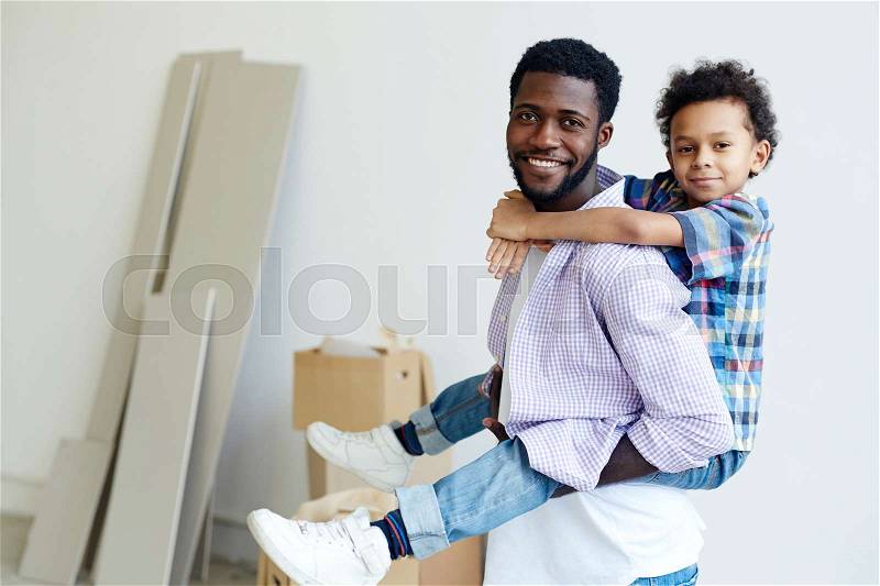 Happy settlers of new flat - man and his son, stock photo