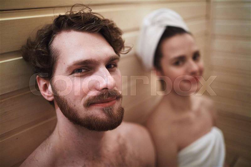 Young relaxed couple enjoying time in sauna, stock photo