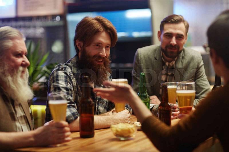 Friendly guys with beer spending evening in pub, stock photo