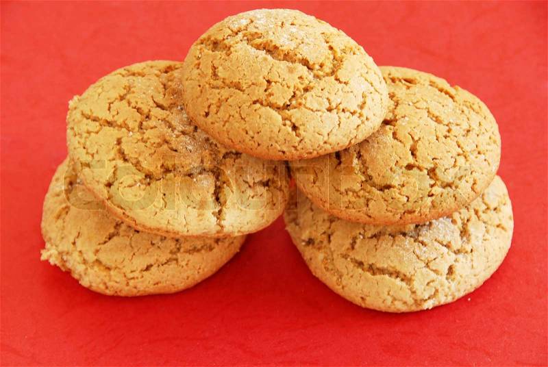 Five fresh appetizing oatmeal cookies over red background, stock photo