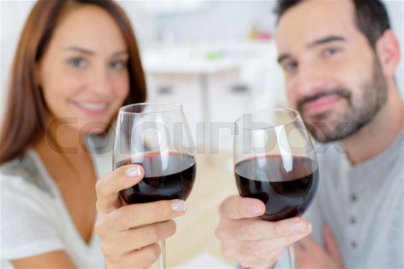 Couple enjoying a glass of wine at home, stock photo