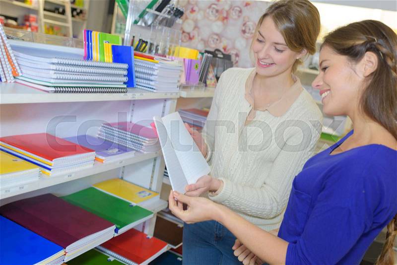 Women looking at books in stationery shop, stock photo