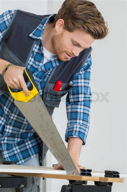 Worker works with handsaw, stock photo