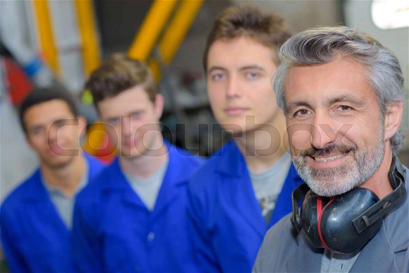 Tradesman with his three apprentices, stock photo