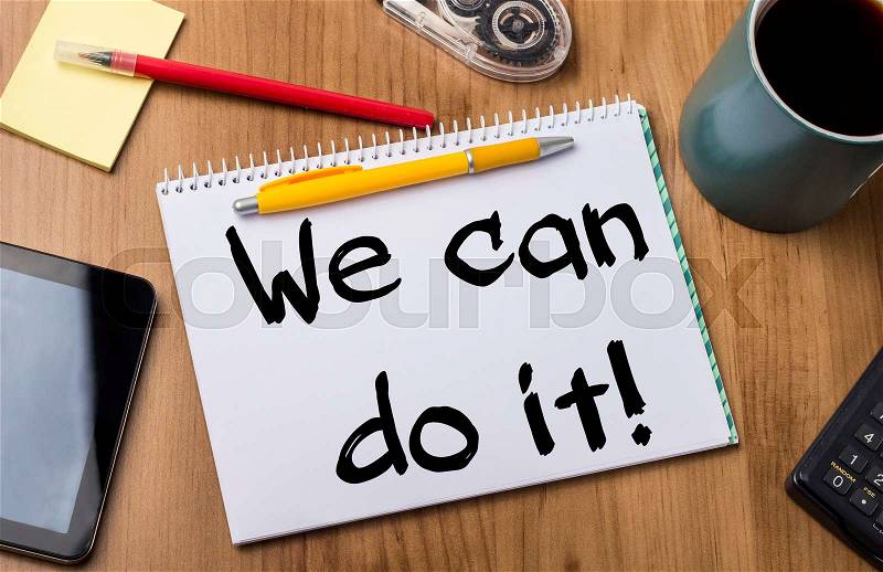 We can do it! - Note Pad With Text On Wooden Table - with office tools, stock photo