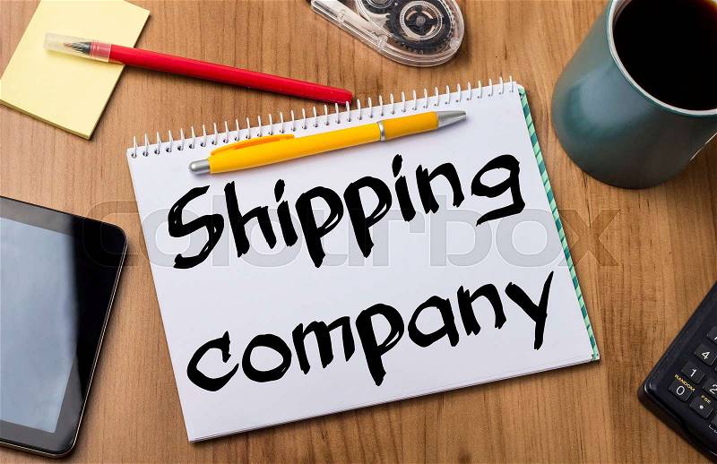 Shipping company - Note Pad With Text On Wooden Table - with office tools, stock photo