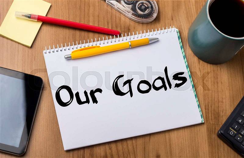 Our Goals - Note Pad With Text On Wooden Table - with office tools, stock photo