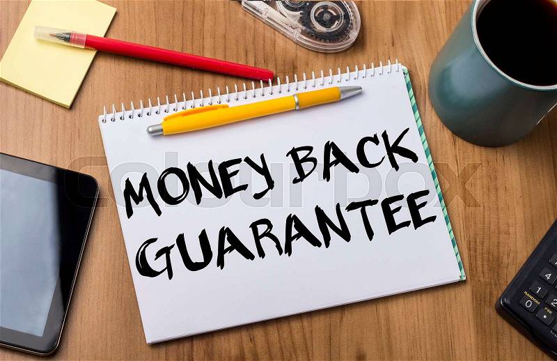 MONEY BACK GUARANTEE - Note Pad With Text On Wooden Table - with office tools, stock photo