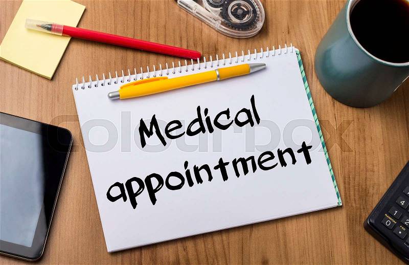 Medical appointment - Note Pad With Text On Wooden Table - with office tools, stock photo