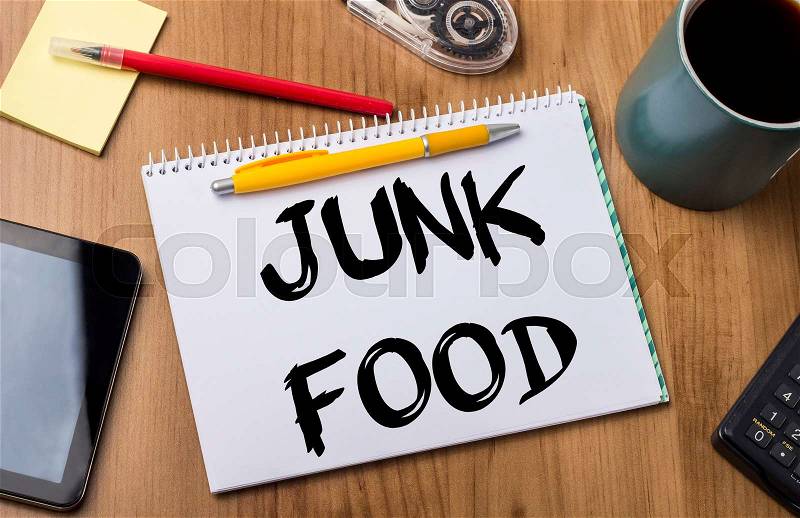 JUNK FOOD - Note Pad With Text On Wooden Table - with office tools, stock photo