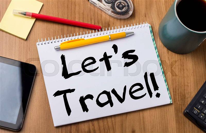 Let’s travel! - Note Pad With Text On Wooden Table - with office tools, stock photo