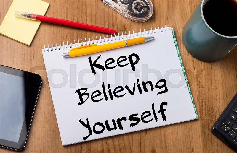 Keep Believing Yourself KEY - Note Pad With Text On Wooden Table - with office tools, stock photo