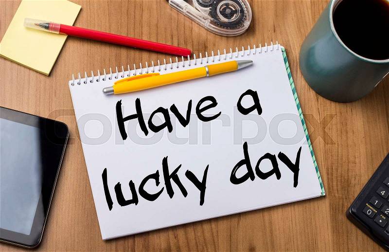 Have a lucky day - Note Pad With Text On Wooden Table - with office tools, stock photo