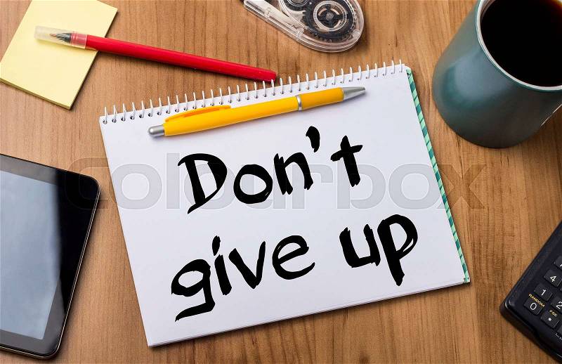 Don’t give up - Note Pad With Text On Wooden Table - with office tools, stock photo