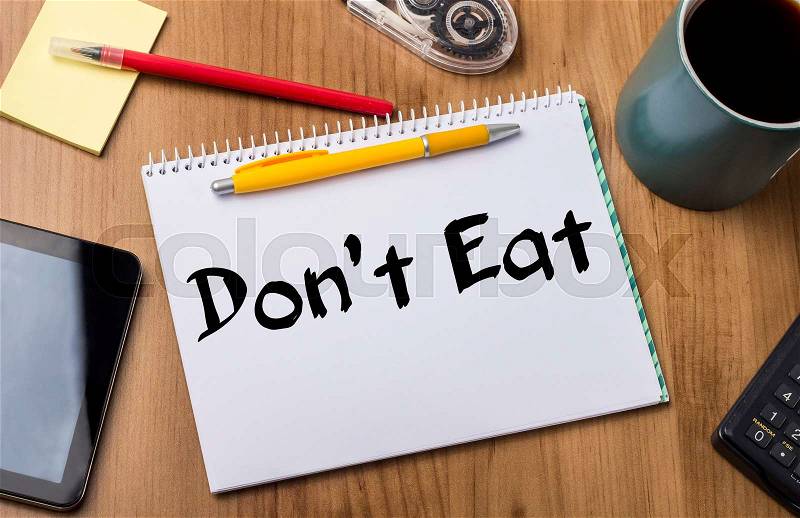 Don’t Eat - Note Pad With Text On Wooden Table - with office tools, stock photo