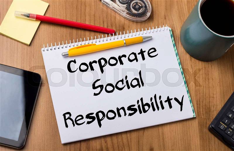 Corporate Social Responsibility CSR - Note Pad With Text On Wooden Table - with office tools, stock photo
