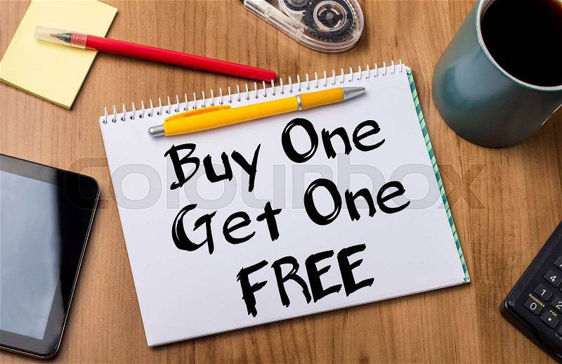 Buy One Get One FREE - Note Pad With Text On Wooden Table - with office tools, stock photo