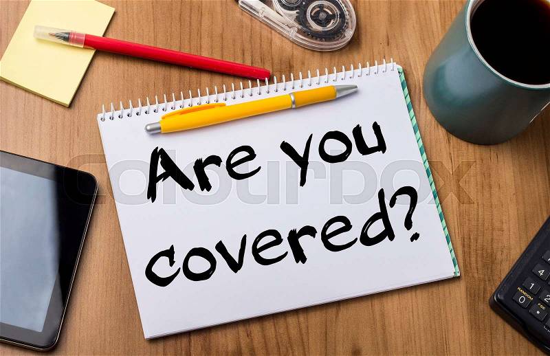 Are you covered? - Note Pad With Text On Wooden Table - with office tools, stock photo