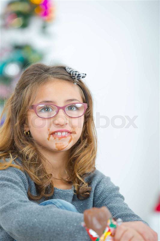 Girl eating chocolate, mouth in a mess, stock photo