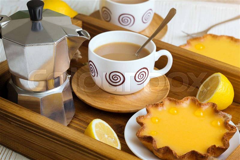 Breakfast - a tray of lemon tarts and coffee , stock photo