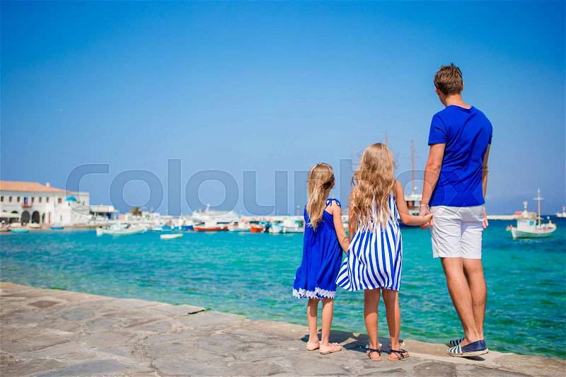 Family vacation in Europe. Father and kids background Mykonos town in Greece, stock photo