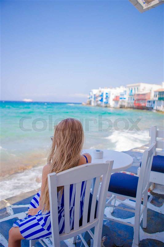 Adorable little girl at Little Venice the most popular tourist area on Mykonos island, Greece, stock photo