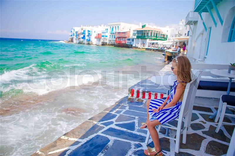 Adorable little girl at Little Venice the most popular tourist area on Mykonos island, Greece, stock photo