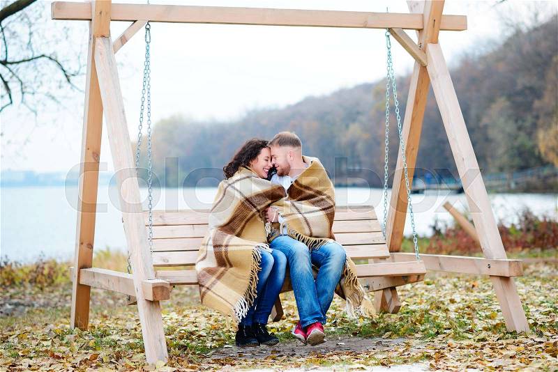 Amorous couple on romantic date on swings outdoor ,autumn, stock photo