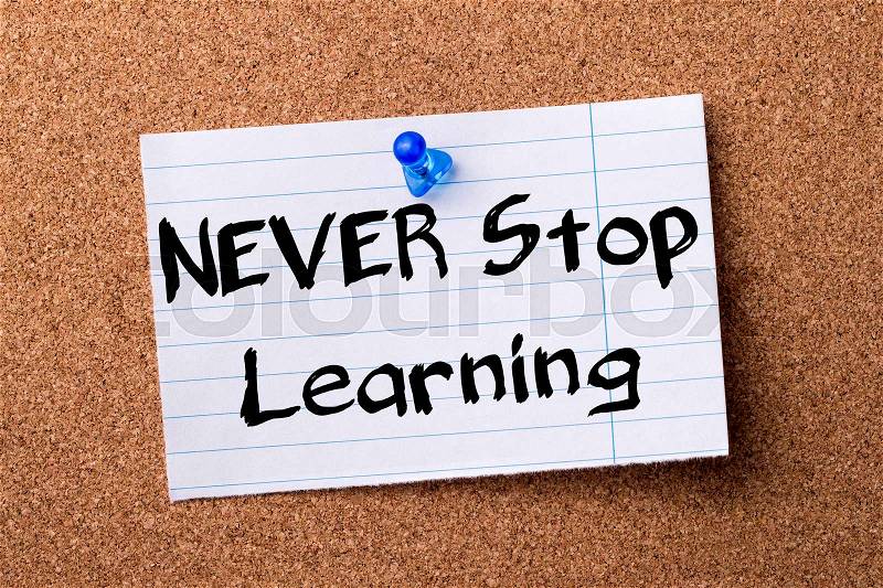 NEVER Stop Learning - teared note paper pinned on bulletin board - horizontal image, stock photo